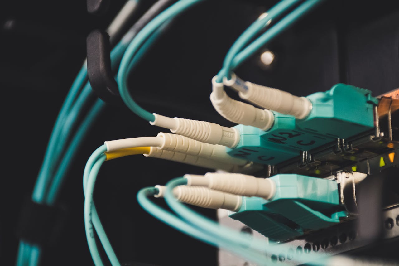 hero-02 Detailed view of fiber optic cables and ports in a server room, showcasing connectivity.
