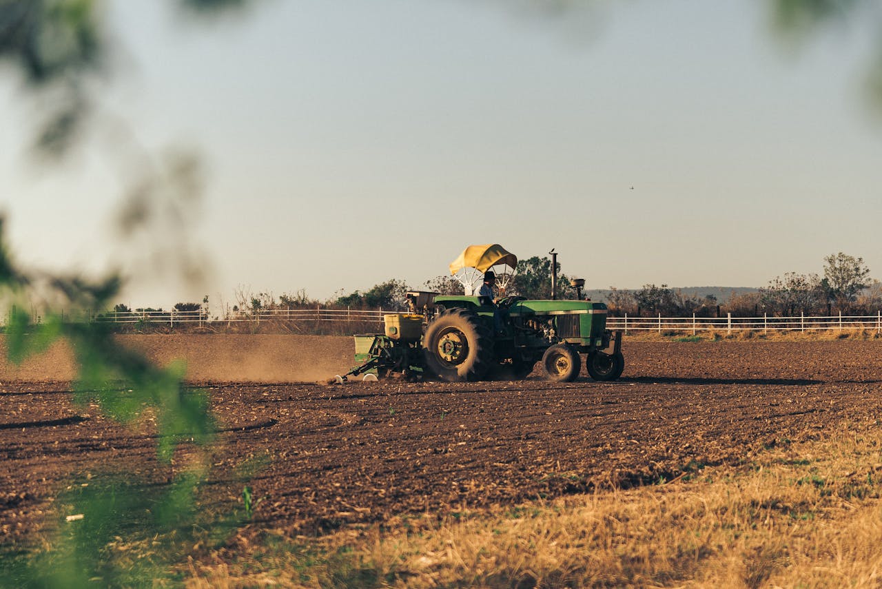 services-09 A tractor plows through cropland at dusk, showcasing agricultural life in a rural setting.